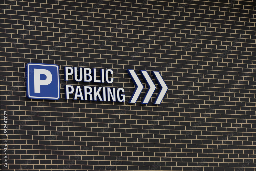 Parking road sign with arrows on a brick wall. Parking road sign with arrows on a brick wall.