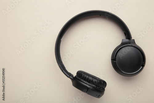 Black, modern wireless headphones on a grey background.
