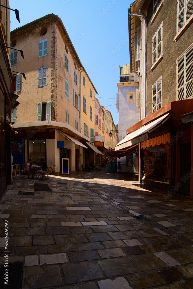 view on the pedestrian of the old city of Hyères with shops on a sunny summerday with warm colours