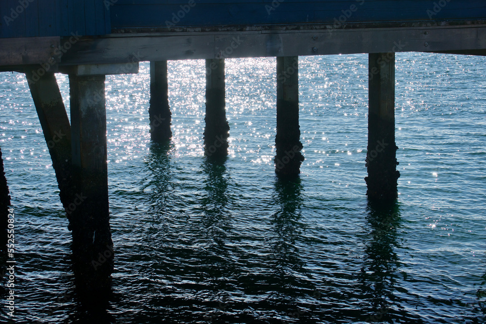 sunset reflection on the water under the pier