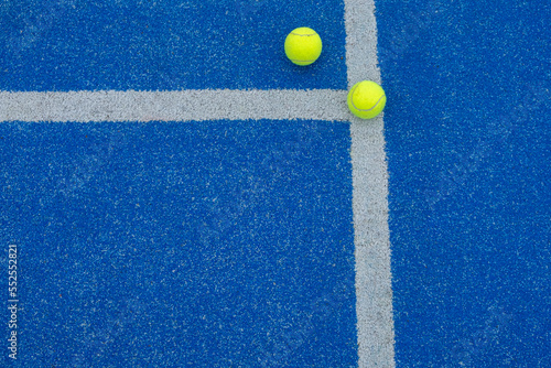 selective focus, two balls on a blue paddle tennis court where the lines connect © VicVaz