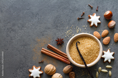 Christmas cookies, nuts and aromatic spices on dark background