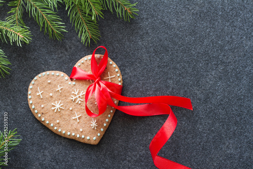 Christmas gingerbread heart with red bow and spruce branches