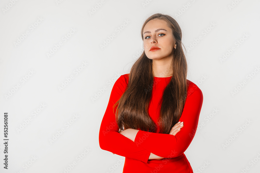 Portrait of beautiful young woman with long hair. Confident businesswoman with crossed arms looking at camera, standing against white studio background Portrait of beautiful young woman with long hair. Confident businesswoman with crossed arms looking at camera, standing against white studio background