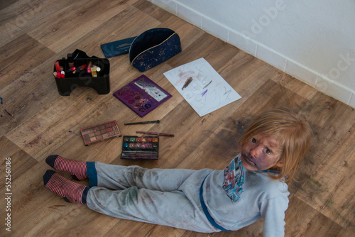 Fotografia Toddler mischief when left alone, child smears makeup all over face and messed i