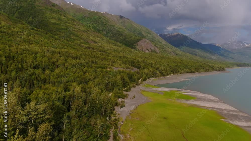 Epic wild Alaskan landscape with pine trees forest and mountain range to reveal beautiful massive lake, Aerial shot Epic wild Alaskan landscape with pine trees forest and mountain range to reveal beautiful massive lake, Aerial shot