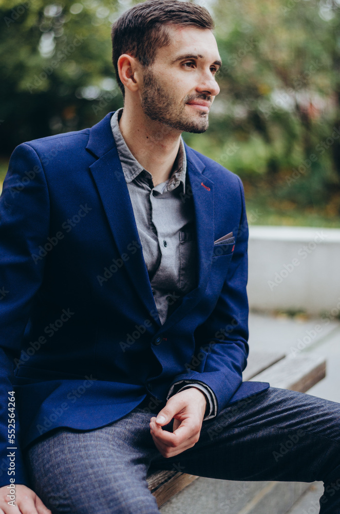Obraz premium a man in a suit is sitting on a bench and smiling