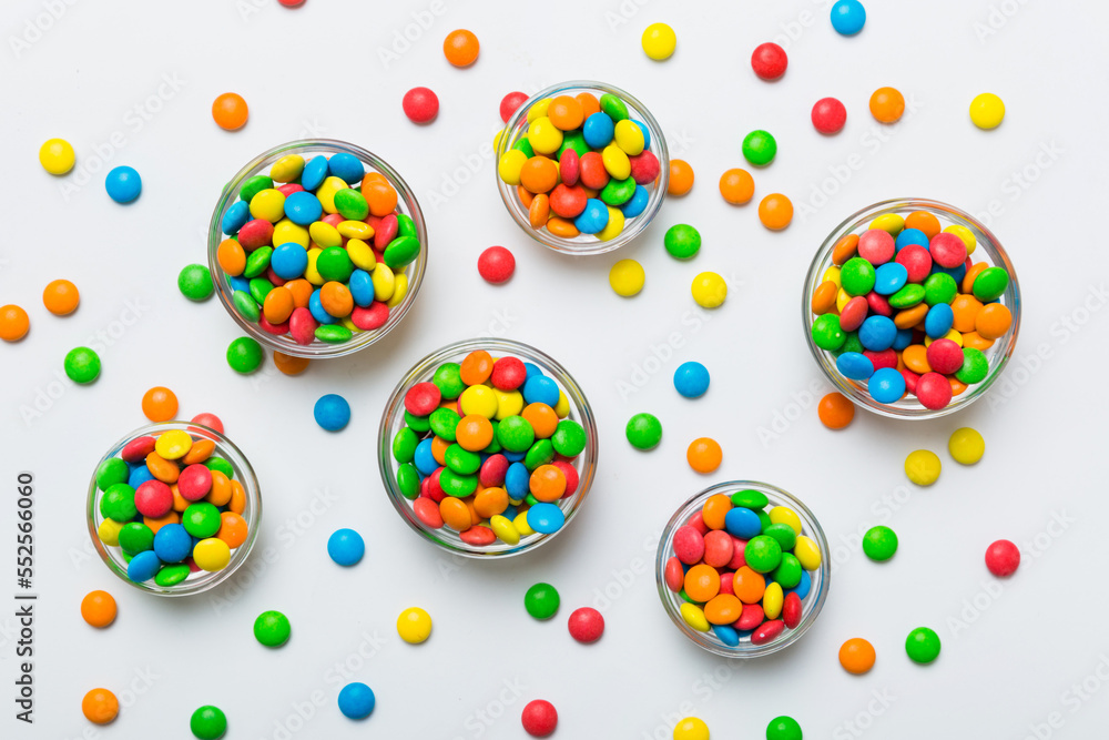 different colored round candy in bowl and jars. Top view of large variety sweets and candies with copy space different colored round candy in bowl and jars. Top view of large variety sweets and candies with copy space