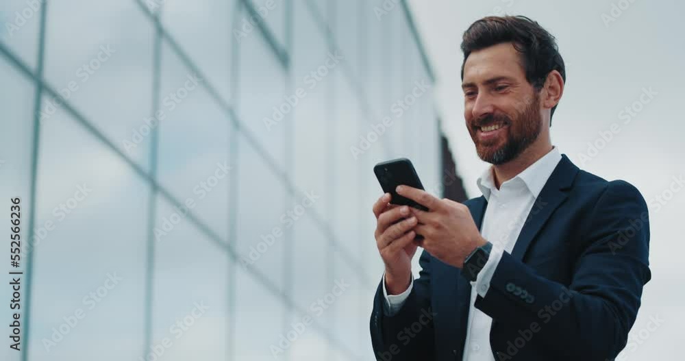 Businessman uses mobile phone and having online chatting during walk Businessman uses mobile phone and having online chatting during walk