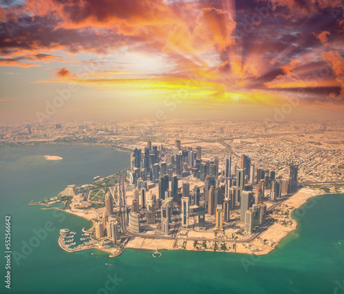 Aerial view of Doha skyline from airplane. Modern skyscrapers at sunset, Qatar