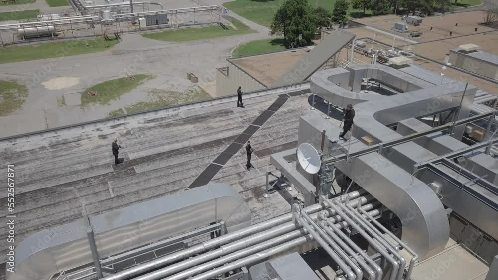 Static aerial shot of armed guards positioned on a rooftop Static aerial shot of armed guards positioned on a rooftop