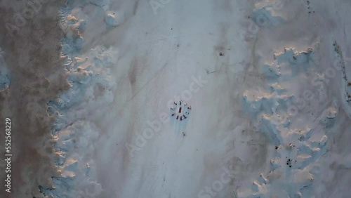 spinning aerial view of a salt field with a group of people lying on the ground forming a circle in meditation photo