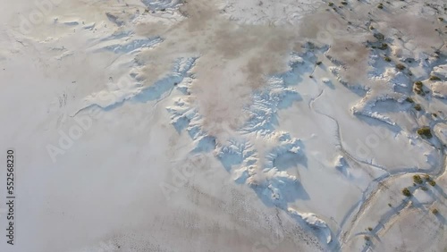 moving aerial view of a salt field, snowy field with little vegetation photo