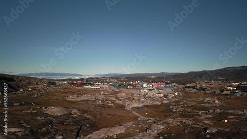 Aerial view of Ilulissat from the ice fiord center. Push in, over the dogs photo