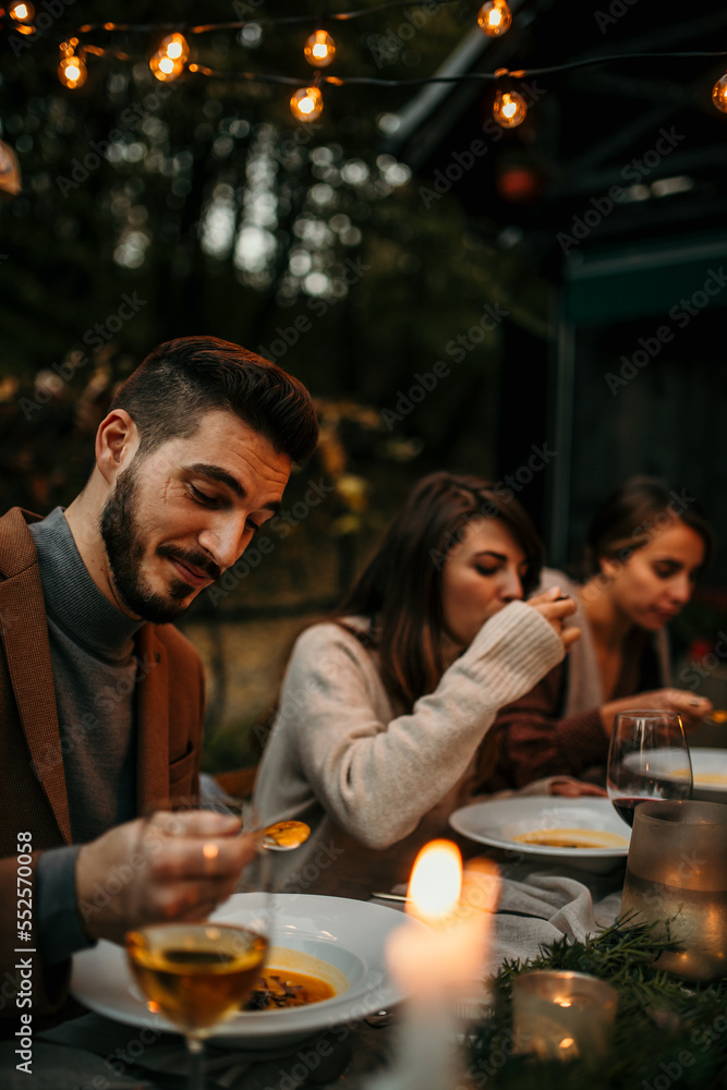 Focus on people eating at the table during a garden party. Food and people concept