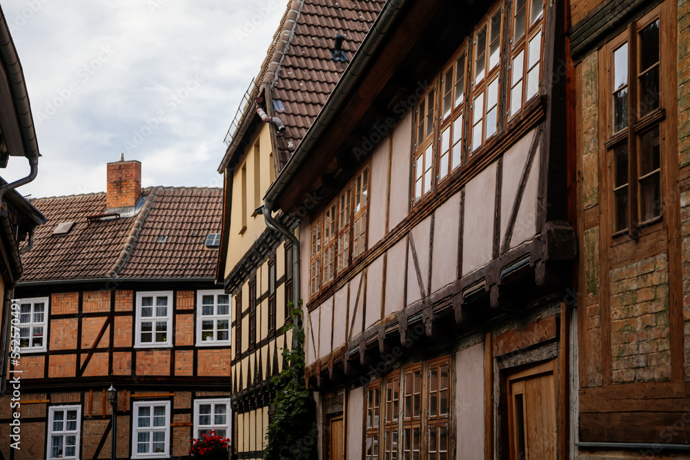 Quedlinburg, Saxony-Anhalt, Germany, 28 October 2022: Historic old vintage colored timber frame houses in medieval town, UNESCO World Heritage city, half-timbered home at sunny autumn day, cobblestone