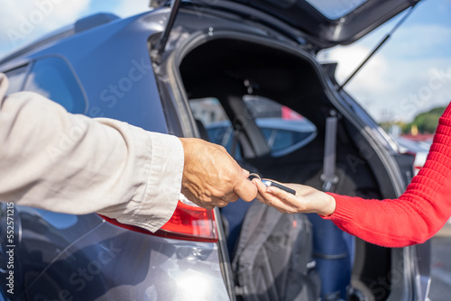 Young woman customers receive car keys from the lessor in the airport to drive travel.