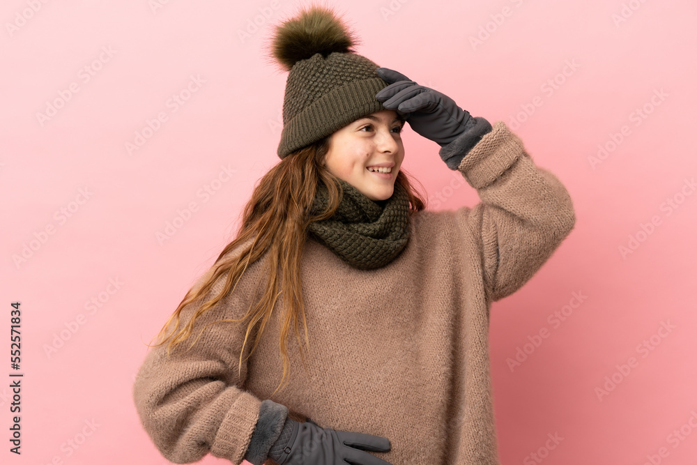 Little girl with winter hat isolated on pink background smiling a lot Little girl with winter hat isolated on pink background smiling a lot