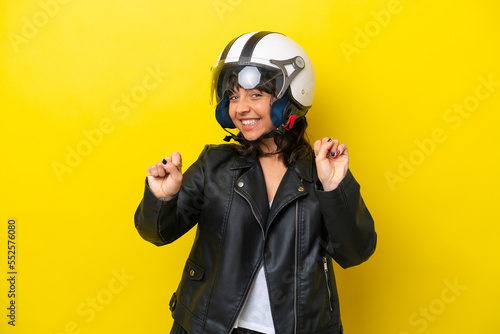 Fototapeta Naklejka Na Ścianę i Meble -  Young latin woman with a motorcycle helmet isolated on yellow background