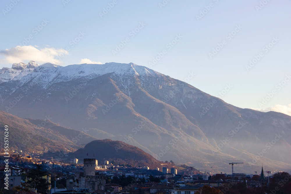 La Vigolana mountain with the city of Trento and the castle, in a winter sunset.
