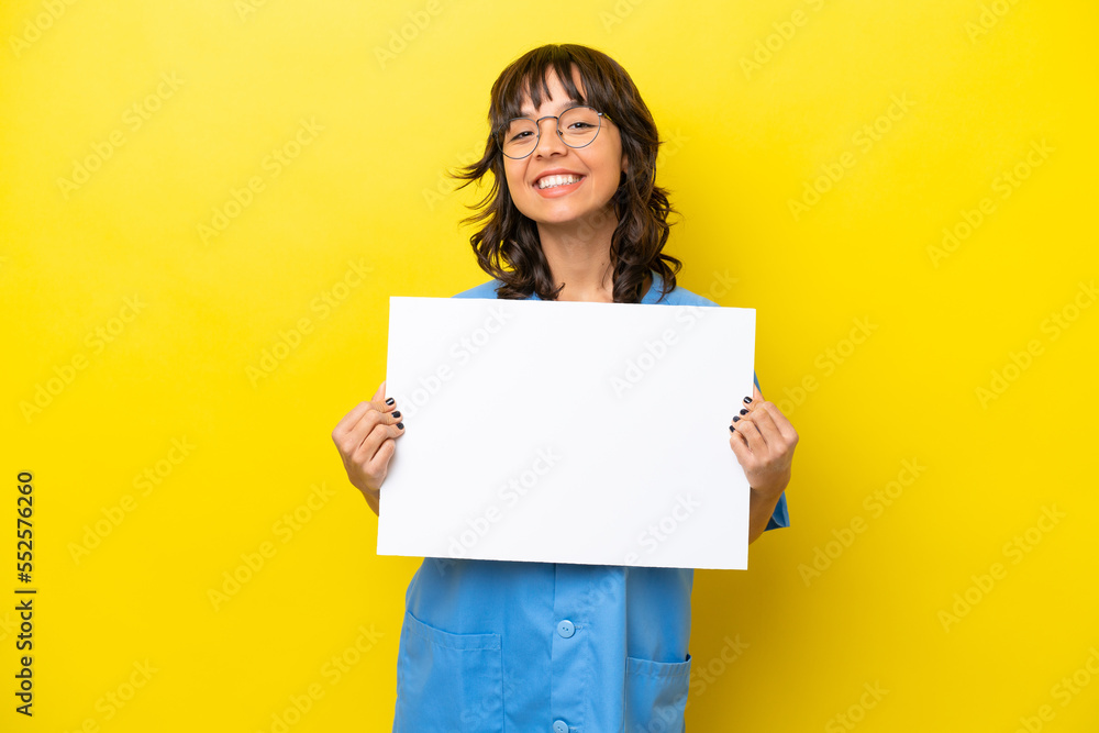 Young nurse doctor woman isolated on yellow background holding an empty placard with happy expression Young nurse doctor woman isolated on yellow background holding an empty placard with happy expression