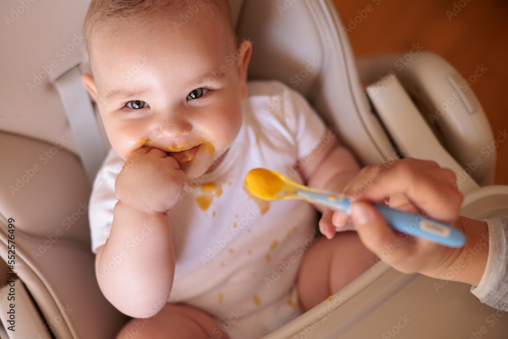 Mother feeding porridge to baby boy Mother feeding porridge to baby boy