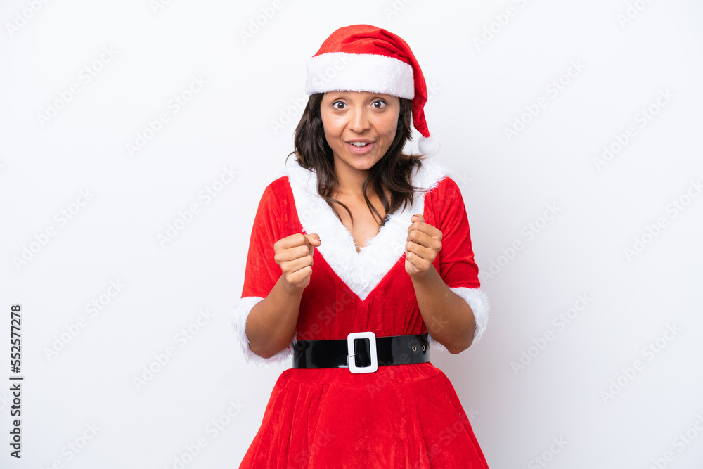 Young hispanic woman dressed as mama noel isolated on white background celebrating a victory in winner position Young hispanic woman dressed as mama noel isolated on white background celebrating a victory in winner position
