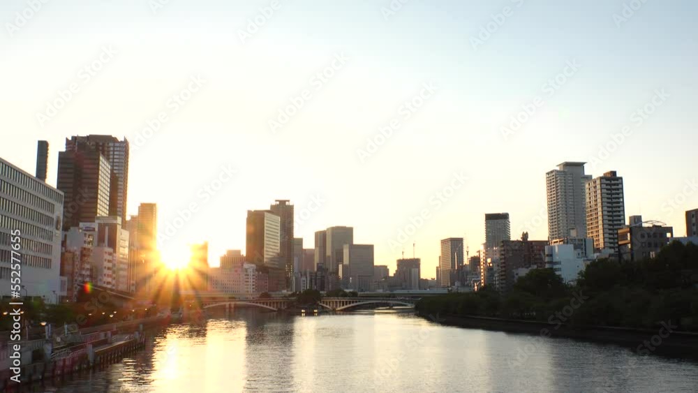 OSAKA, JAPAN - SEP 2022 : View of office buildings at Kitahama area and river in sunset. Large business district in Osaka. Japanese business, company, real estate and urban city concept video. OSAKA, JAPAN - SEP 2022 : View of office buildings at Kitahama area and river in sunset. Large business district in Osaka. Japanese business, company, real estate and urban city concept video.