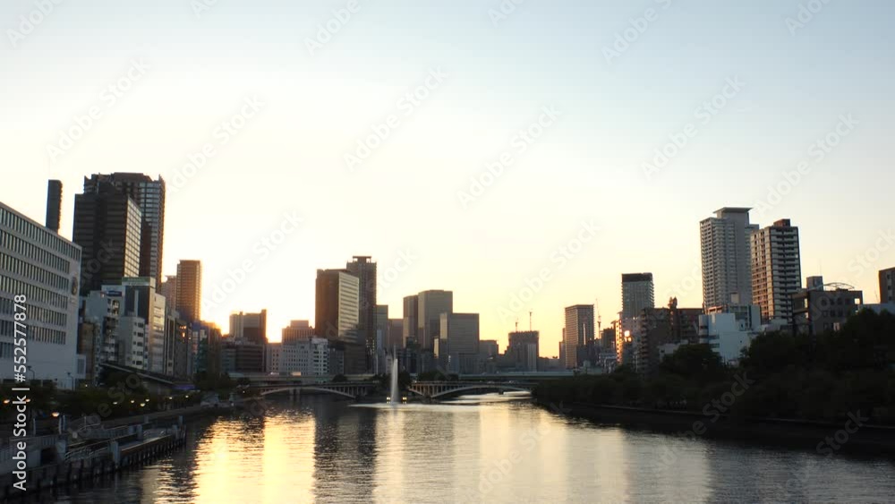 OSAKA, JAPAN - SEP 2022 : View of office buildings at Kitahama area and river in sunset. Large business district in Osaka. Japanese business, company, real estate and urban city concept video. OSAKA, JAPAN - SEP 2022 : View of office buildings at Kitahama area and river in sunset. Large business district in Osaka. Japanese business, company, real estate and urban city concept video.