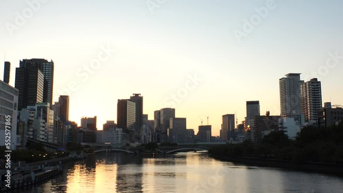 OSAKA, JAPAN - SEP 2022 : View of office buildings at Kitahama area and river in sunset. Large business district in Osaka. Japanese business, company, real estate and urban city concept video. photo