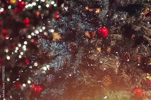 Christmas trees decorated with colorful balls and bokeh. Festive background