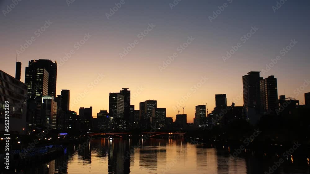 OSAKA, JAPAN - SEP 2022 : View of office buildings at Kitahama area and river in sunset. Large business district in Osaka. Japanese business, company, real estate and urban city concept video. OSAKA, JAPAN - SEP 2022 : View of office buildings at Kitahama area and river in sunset. Large business district in Osaka. Japanese business, company, real estate and urban city concept video.