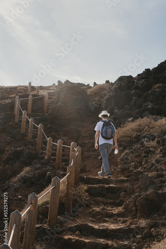 Young man climbing steps of a trail over a volcano
