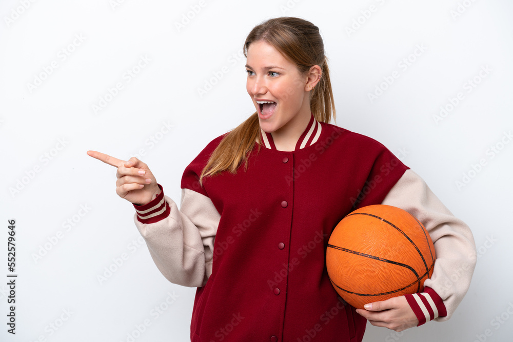 Young basketball player woman isolated on white background pointing finger to the side and presenting a product Young basketball player woman isolated on white background pointing finger to the side and presenting a product