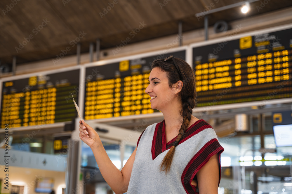 smiling woman at the airport waits to go on vacation.