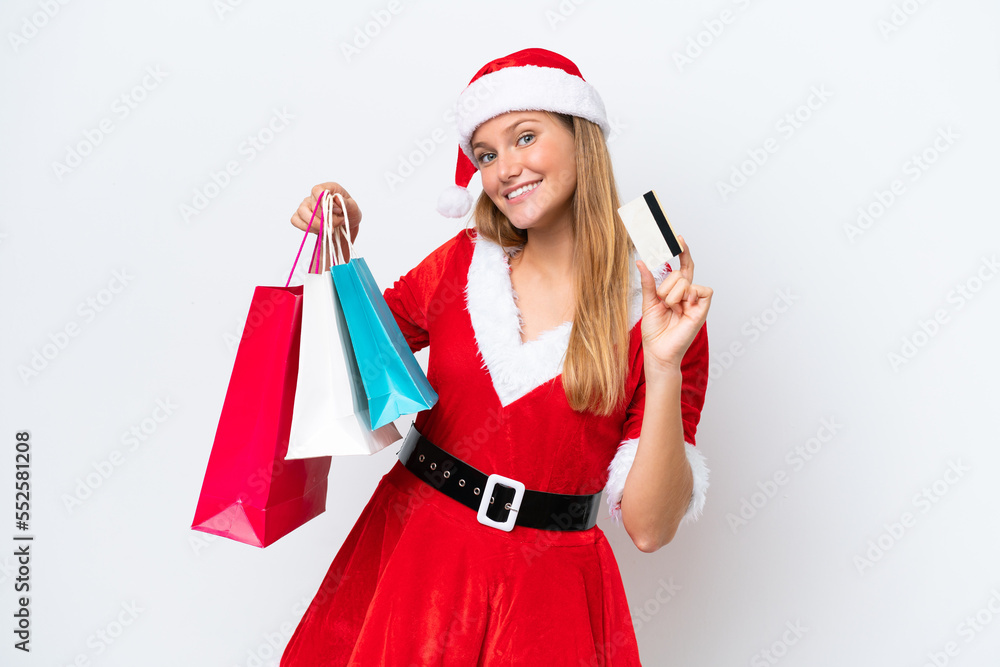 Young caucasian woman dressed as mama noel isolated on white background holding shopping bags and a credit card Young caucasian woman dressed as mama noel isolated on white background holding shopping bags and a credit card