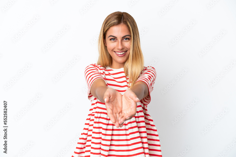 Blonde Uruguayan girl isolated on white background holding copyspace imaginary on the palm to insert an ad Blonde Uruguayan girl isolated on white background holding copyspace imaginary on the palm to insert an ad