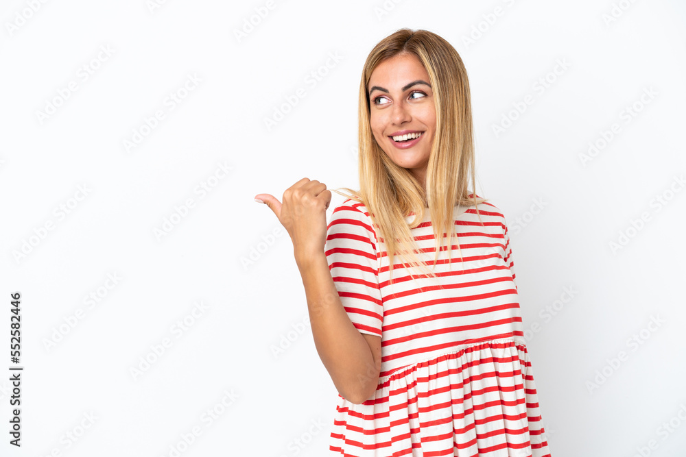 Blonde Uruguayan girl isolated on white background pointing to the side to present a product Blonde Uruguayan girl isolated on white background pointing to the side to present a product