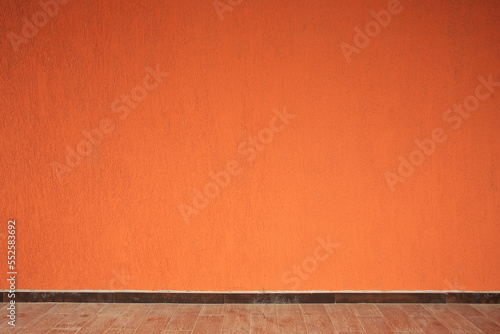 Beautiful orange wall and wooden floor made of planks