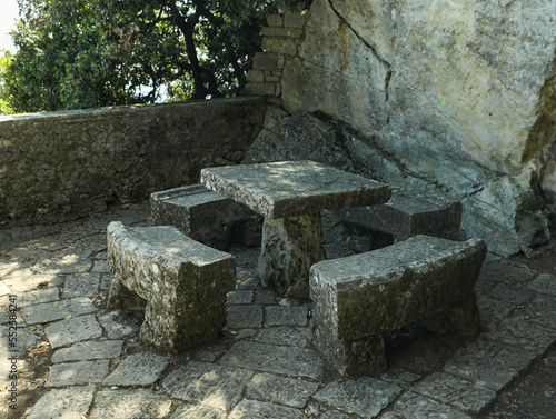 Stone table and benches near rock outdoors