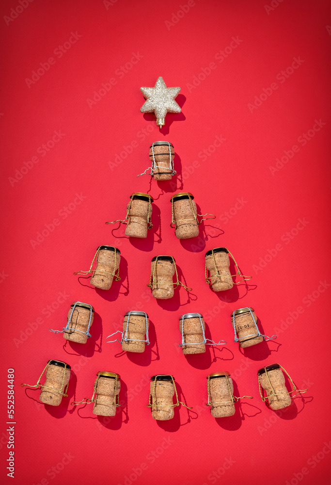 Silhouette of Christmas tree made from champagne corks on red background. Merry Christmas and Happy New Year concept Silhouette of Christmas tree made from champagne corks on red background. Merry Christmas and Happy New Year concept