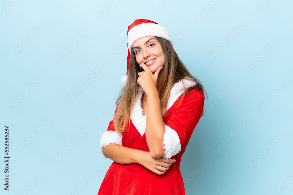 Young caucasian woman dressed as mama noel isolated on blue background smiling Young caucasian woman dressed as mama noel isolated on blue background smiling