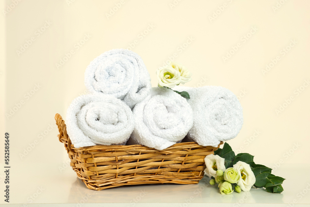 Soft folded towels and flowers on white table Soft folded towels and flowers on white table