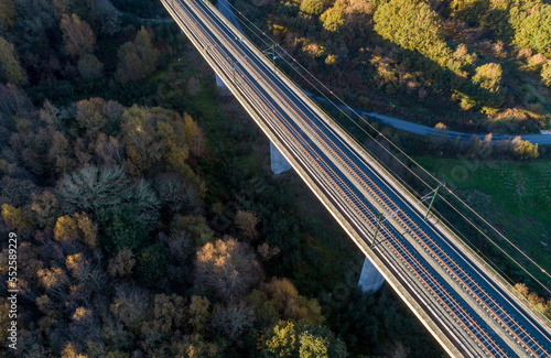 drone aerial view of a high speed railway line on a bridgeat sunset