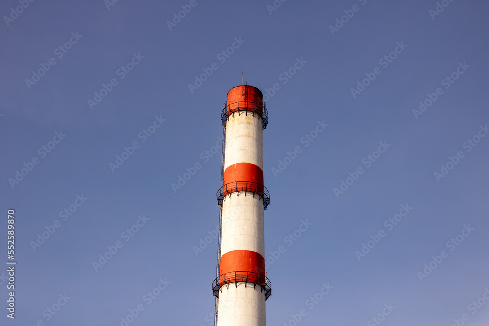 Red and white pipe of plant against background of blue sky Red and white pipe of plant against background of blue sky