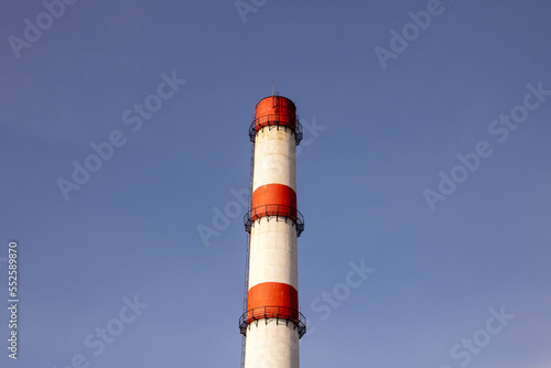 Red and white pipe of plant against background of blue sky