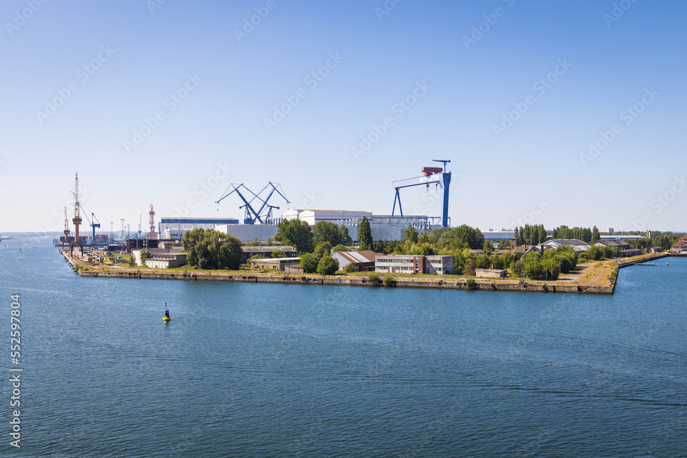 Industrial area in Rostock port harbor with cranes, facilities and docks