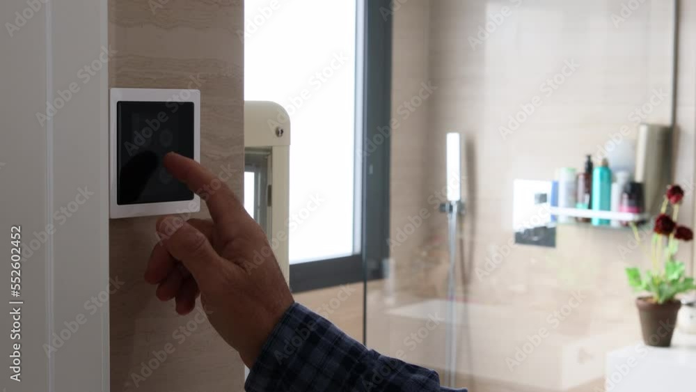 Close-up of man's hand adjusting the temperature on a home automation screen Close-up of man's hand adjusting the temperature on a home automation screen