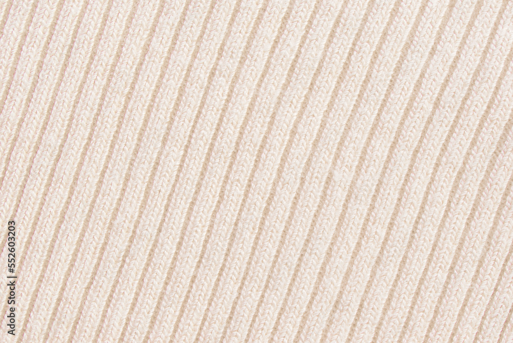 Soft beige ribbed knit fabric pattern close up as background Soft beige ribbed knit fabric pattern close up as background