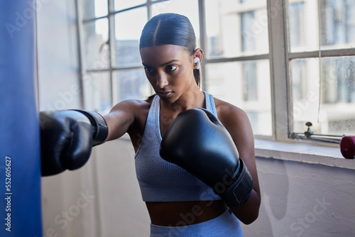 Boxing, woman and music for fitness motivation with audio podcast for boxer competition, boxing gloves and exercise training in gym. Sports workout, streaming radio and athlete focus for fist fight